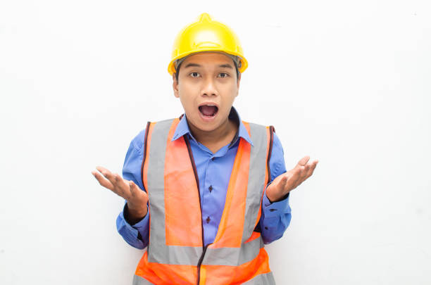 istock asian construction worker wearing yellow safety helmet shouting with shocked and surprised expression. 1469753601