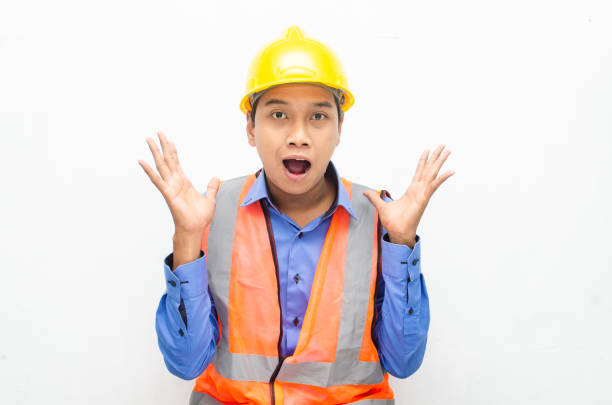 istock asian construction worker wearing yellow safety helmet shouting with shocked and surprised expression. 1469753602