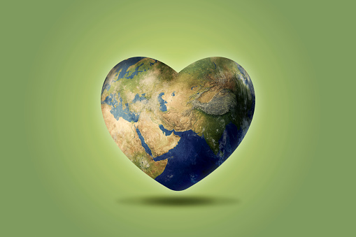 The globe is shaped in the shape of a heart on a green background. Concept of saving the world. 3D illustration.