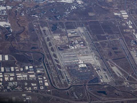 Aerial view of Salt Lake City International Airport in winter showing all runways and ongoing construction.