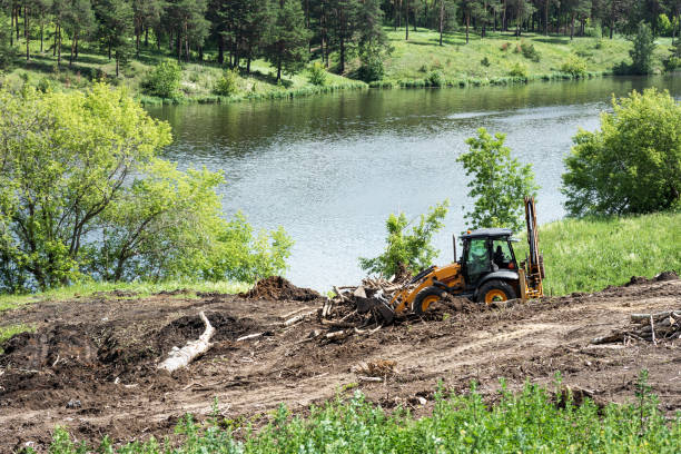 tractor works in the park for landscaping next to the river. building a path in the park