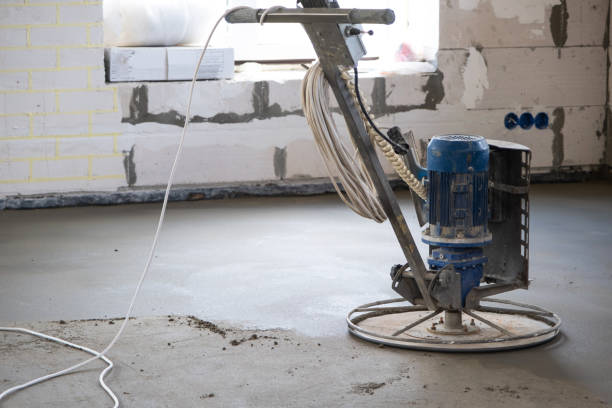 istock Ramming and grinding of semi-dry floor screed by a machine with a rotating disk for leveling. Construction of a concrete floor in the house, a master with special equipment. 1469754757