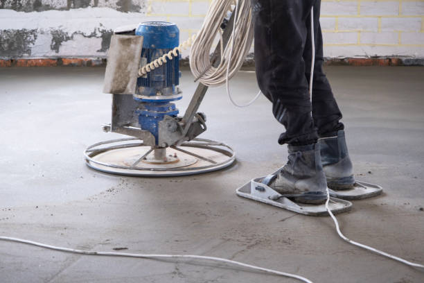 istock Ramming and grinding of semi-dry floor screed by a machine with a rotating disk for leveling. Construction of a concrete floor in the house, a master with special equipment. 1469754758