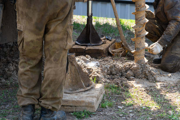 Team of workers with drilling rig on car are drilling artesian well for water in ground. Insertion of metal casing pipe into ground, installation of individual drinking supply, June 28, 2022, Russia, un equipo de trabajadores con plataforma de perforación en el automóvil está perforando pozos artesianos para obtener agua en el suelo. inserción de tubería metálica en el suelo, instalación de suministro individual de agua potable, 28 de junio de 2