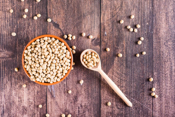 istock Raw soybean seeds in a bowl, spoon and jar on the table. Source of vegetable protein. Top view 1469760724