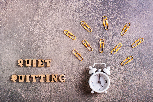 Quiet quitiing wooden letters and a ringing alarm clock. Do nothing beyond your official duties.