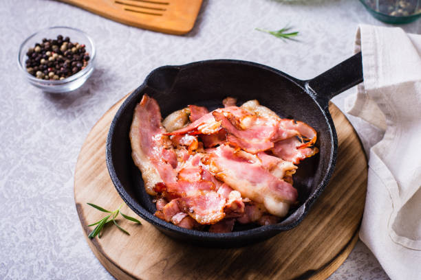 istock Crispy strips of bacon fried in a pan on the table. 1469761075