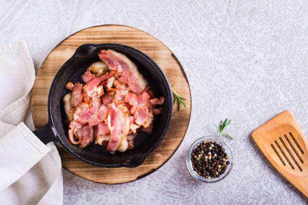 istock Fried bacon in a pan ready for dinner on the table. Top view 1469761081