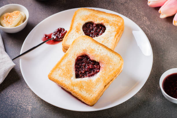 istock Toast with a heart filled with raspberry jam on a plate. Breakfast for a couple. 1469761379