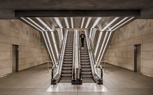 girl standing in the escalator at a metro station in the copenhagen cirkel metro line, February 18, 2023