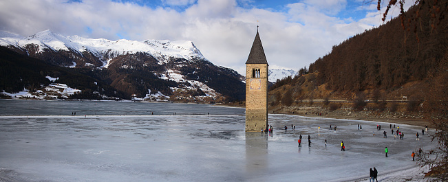 Bell tower on the frozen lake. Lake Resia, province of Trento, Italy.