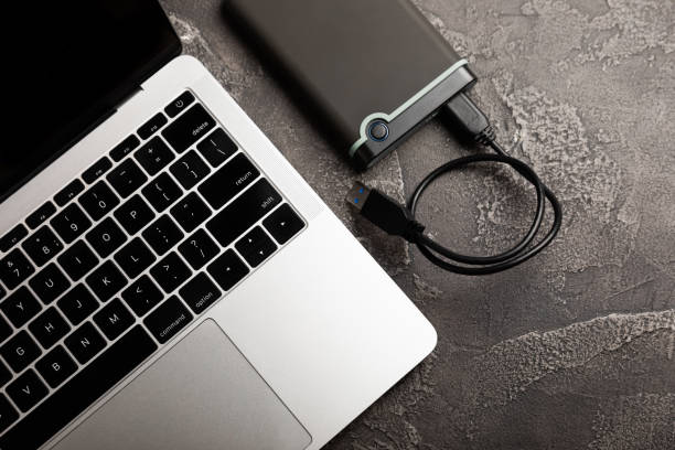 istock External HDD and laptop on black cement background. Place to copy 1469768548