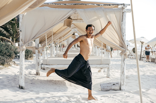 Man doing yoga on beach - stock photo