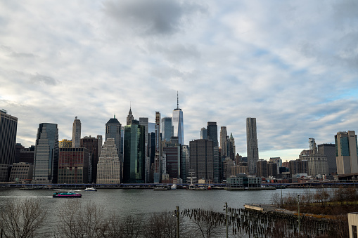 Brooklyn, New York, USA - January 7, 2023: The view of the skyline in lower Manhattan, the Financial District of New York City and the Brooklyn Bridge as viewed from DUMBO, Brooklyn on a winter day.