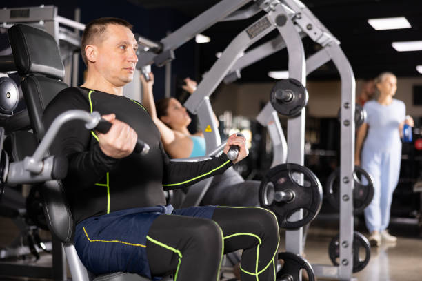 istock Sporty male athlete using arm extension machine in gym 1469780411