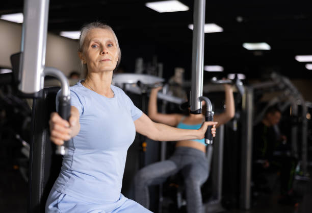 istock Elderly woman exercising chest muscles on butterfly machine 1469781341