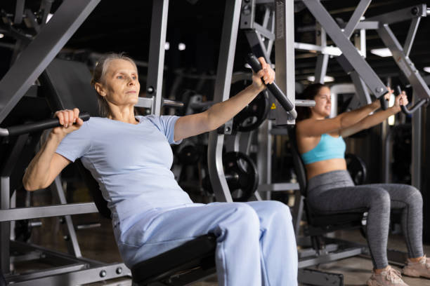 istock Aged woman performing chest press in exercise machine in gym 1469781769