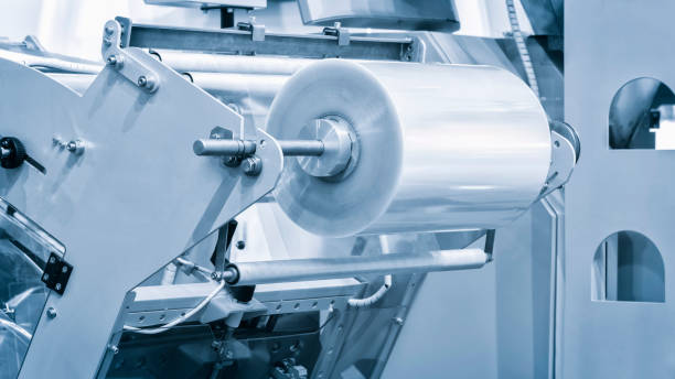 istock Automatic polyethylene plastic bag production machine with lighting effect. Close-up of the roller of the plastic bag production machine in the light blue scene. product packaging concept 1469785691