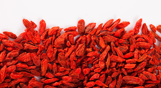 Red dried goji berries on white surface. Natural food background