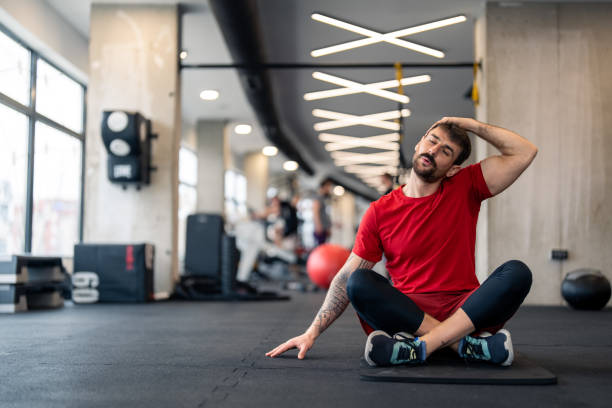 istock Athletic man in sports clothes warming up before workout in gym 1469786838