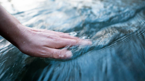 istock A female hand touching the river water 1469788036