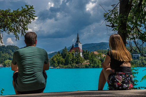 Young couple from behind enjoying the turquoise waters of Lake Bled (Slovenia)