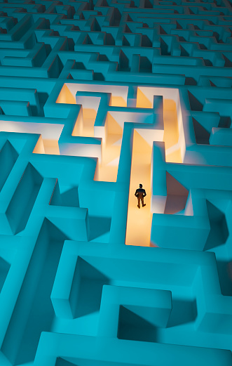 Man stands in the middle of dark maze. Lights guide the way for him. Concept of standing in front of a challenge and finding the right solution to move on.