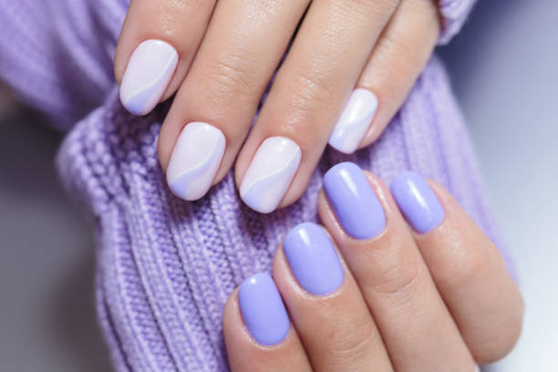 Female hands with a purple colour nails close-up. Nail design. Artistic manicure with a purple nail polish stock photo