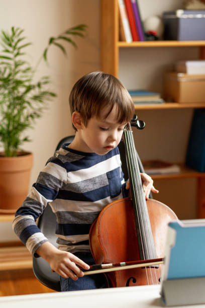 istock A white 5 year old boy is learning to play the cello. uses digital tablet 1469806692