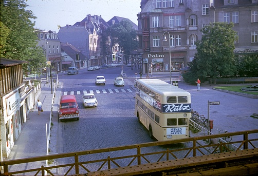 Berlin (West), Germany, 1966. Street scene with traffic, pedestrians, buildings and shops in a southern district of Berlin.