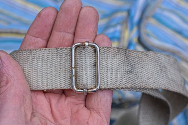 istock hand holds a dirty white harness with gray metal clasp 1469809910