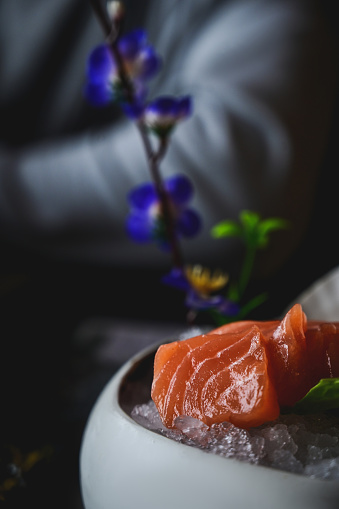 close up with selective focus of salmon sashimi on a plate with ice.
