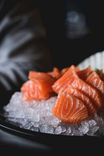 close up of fresh salmon fish in slices on a plate with selective focus.
