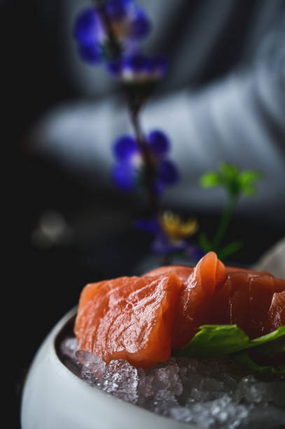 Slice of raw salmon Sashimi in a plate with ice with natural light.