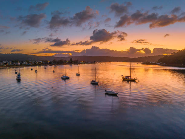istock Sunrise over the water with clouds and boats 1469828886