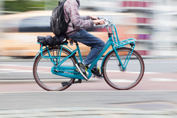 istock young man with a bicycle on the move in the city 1469830111
