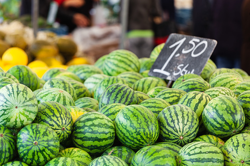 picture of a stack of melons on a stall at a street market