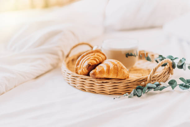 istock Wicker tray with croissants on white bed linen 1469841541