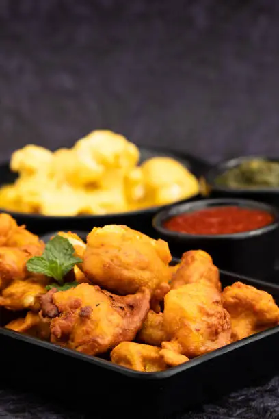 Photo of Namkin Gobi Pakoda Also Called Gobhi Pakora, Pakodi, Fakkura, Bhajiya, Bhajji, Bhaji, Ponako, Bajji Are Tea Time Indian Snacks Made Of Cauliflower Florets Marinated Tossed In Gram Flour Batter, Masala