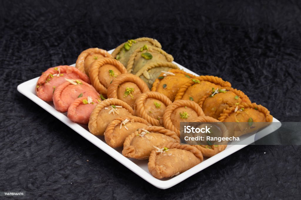 Various Indian Sweet Dumpling Mithai - Rose Gujiya, Karanji, Chandrakala, Suryakala, Kesar Gujia, Thandai Pedakiya Also Called Pirukiya, Pirukia, Basundi, Gughra For Deepawali, Teez Holi, Diwali, Teej Empanada Stock Photo