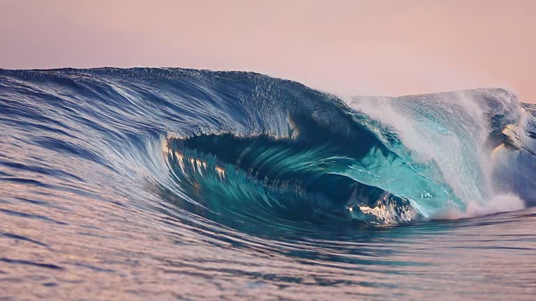 Large unique powerful ocean wave breaking out to sea at sunrise