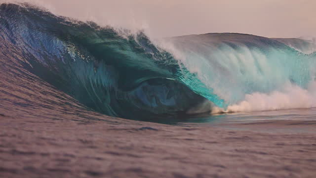 Large unique powerful ocean wave breaking out to sea at sunrise