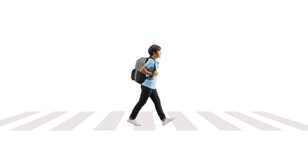 istock Boy with a backpack walking over pedestrian crossing 1469855551