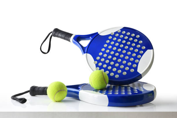 Set of paddle tennis rackets and balls on table isolated stock photo