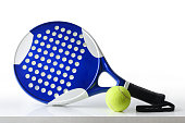Padel racket and ball reflected on table white isolated background
