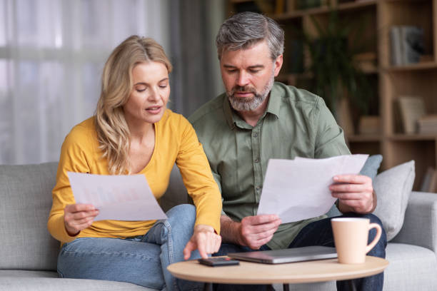 Financial Literacy. Busy Middle Aged Husband And Wife Calculating Family Budget Together stock photo