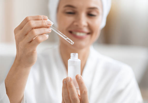 istock Happy woman using moisturizing facial serum, closeup 1469858751