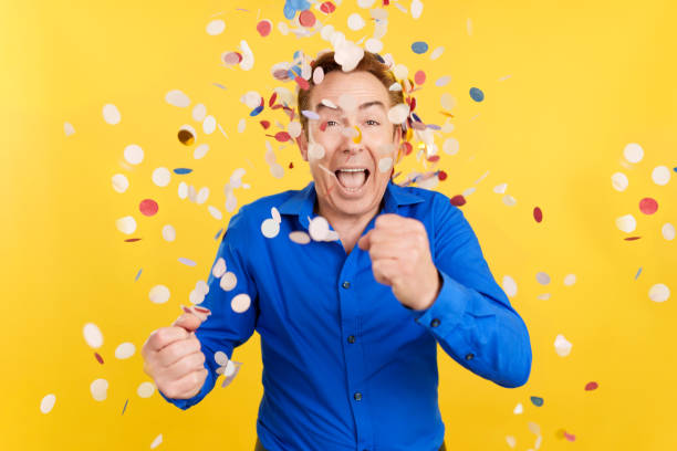 istock Mature man surrounded by confetti flying in the air 1469858983