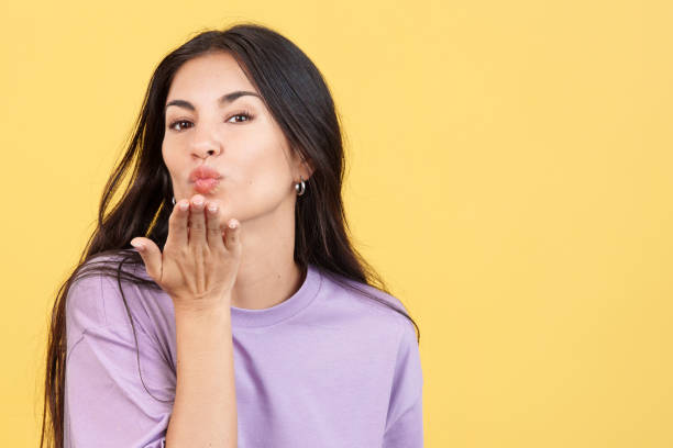 istock Woman blowing a kiss while looking at the camera 1469859043