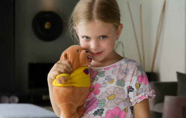 istock Adorable little girl hugging her teddy bear 1469859211